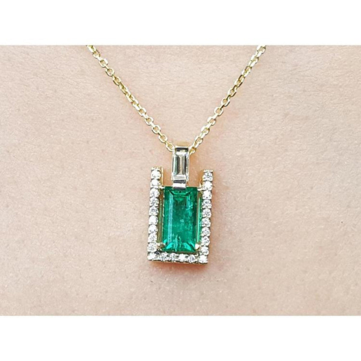 1.14 ct baguette emerald pendant necklace with natural diamonds on a 14K yellow gold chain.