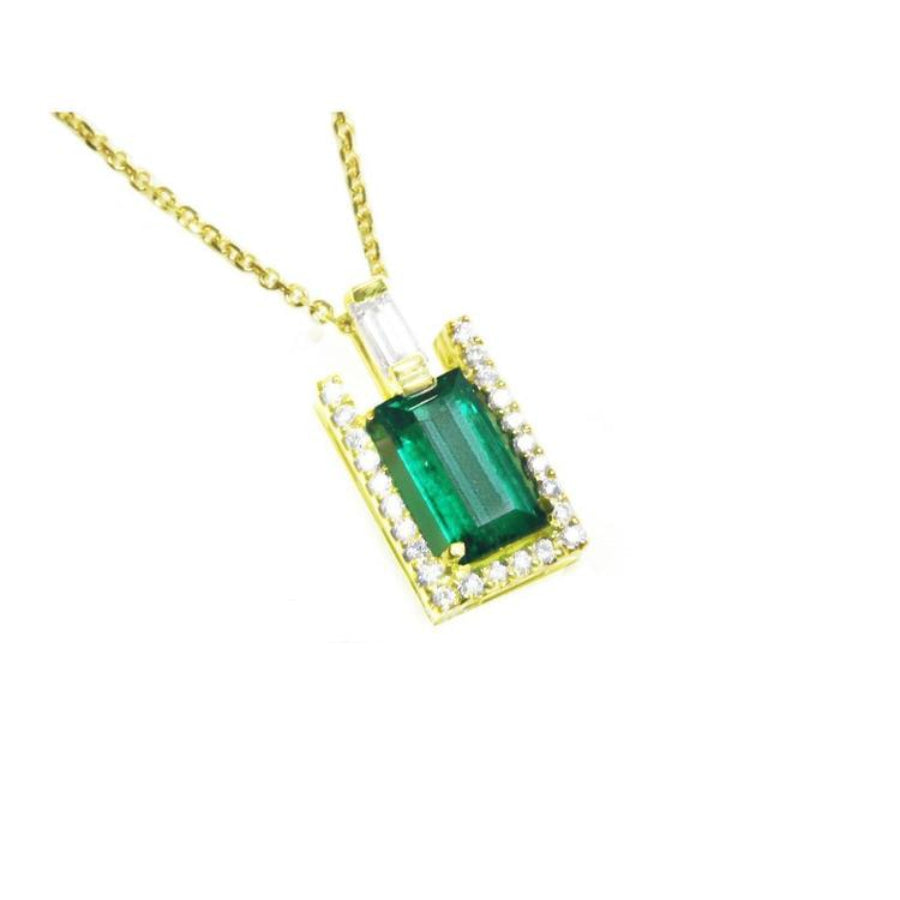 This yellow gold pendant displays a natural colombian emerald baguette cut sourced from the Muzo mines.