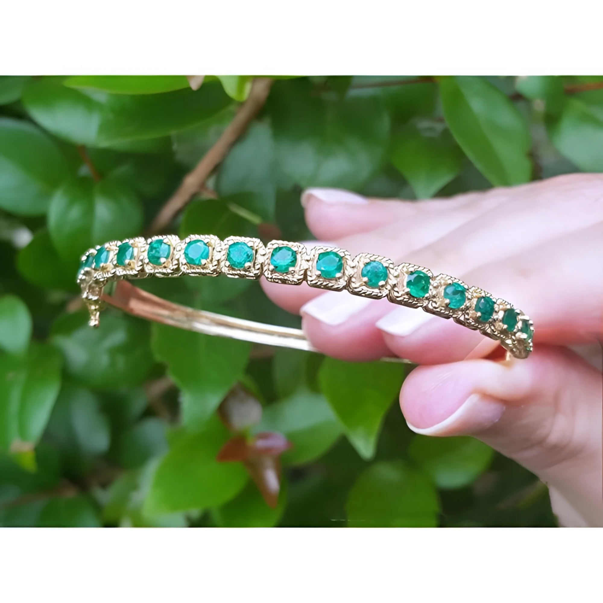 14K gold bangle bracelet with round bluish-green emeralds in square links with rope borders.
