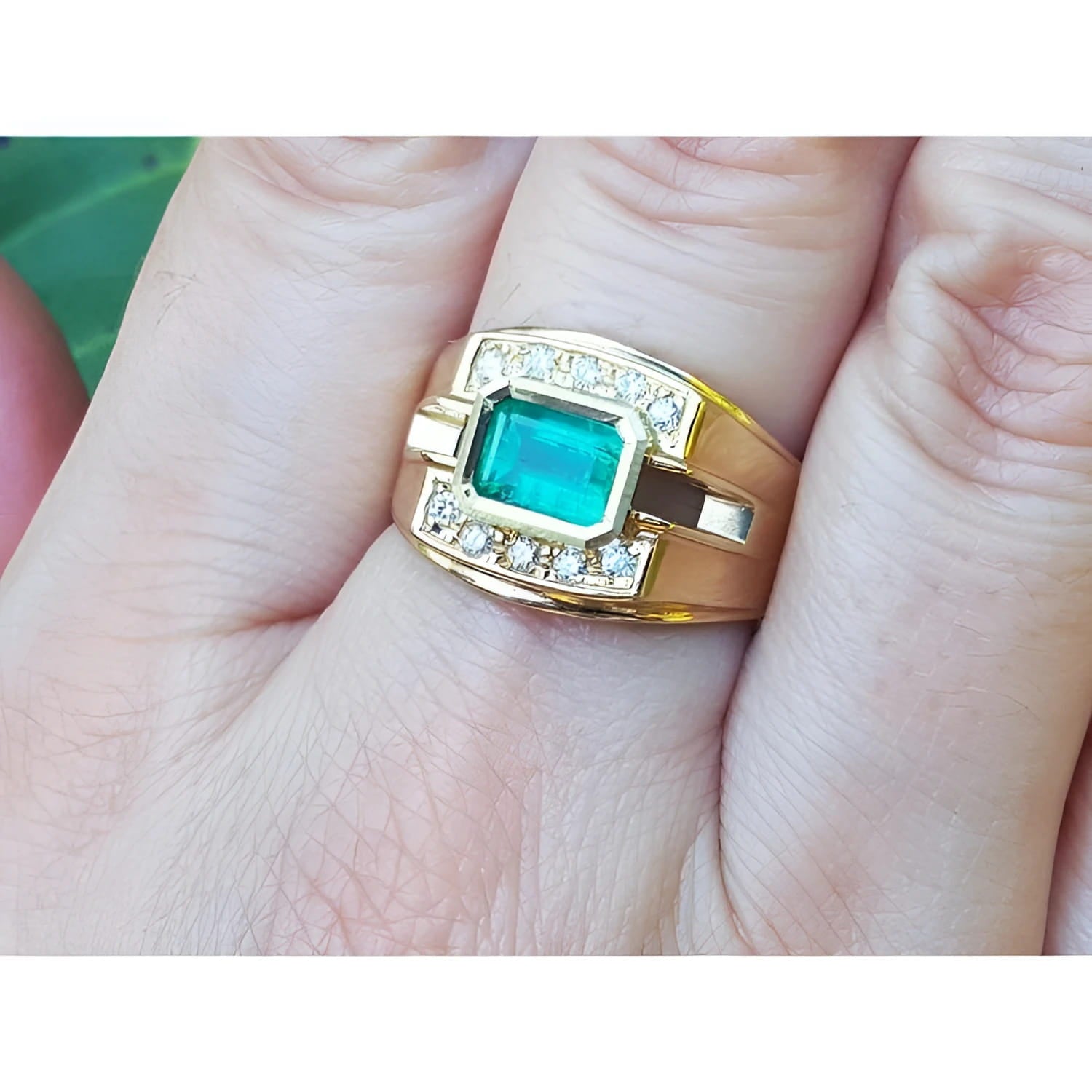 14K yellow gold men's ring with a 1.21 ct. east-west emerald bezel set, surrounded by diamond accents.