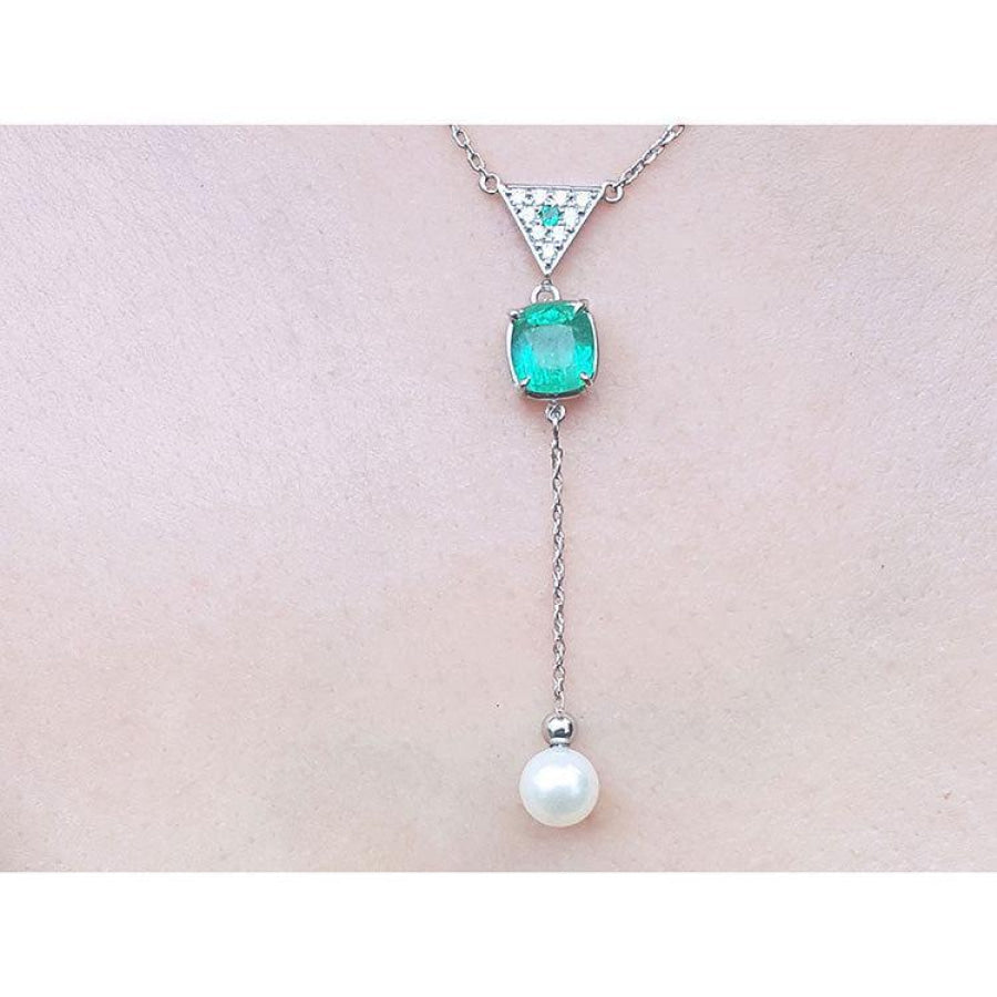 14K white gold necklace with emerald cushion cut, diamond triangle, and hanging white pearl.