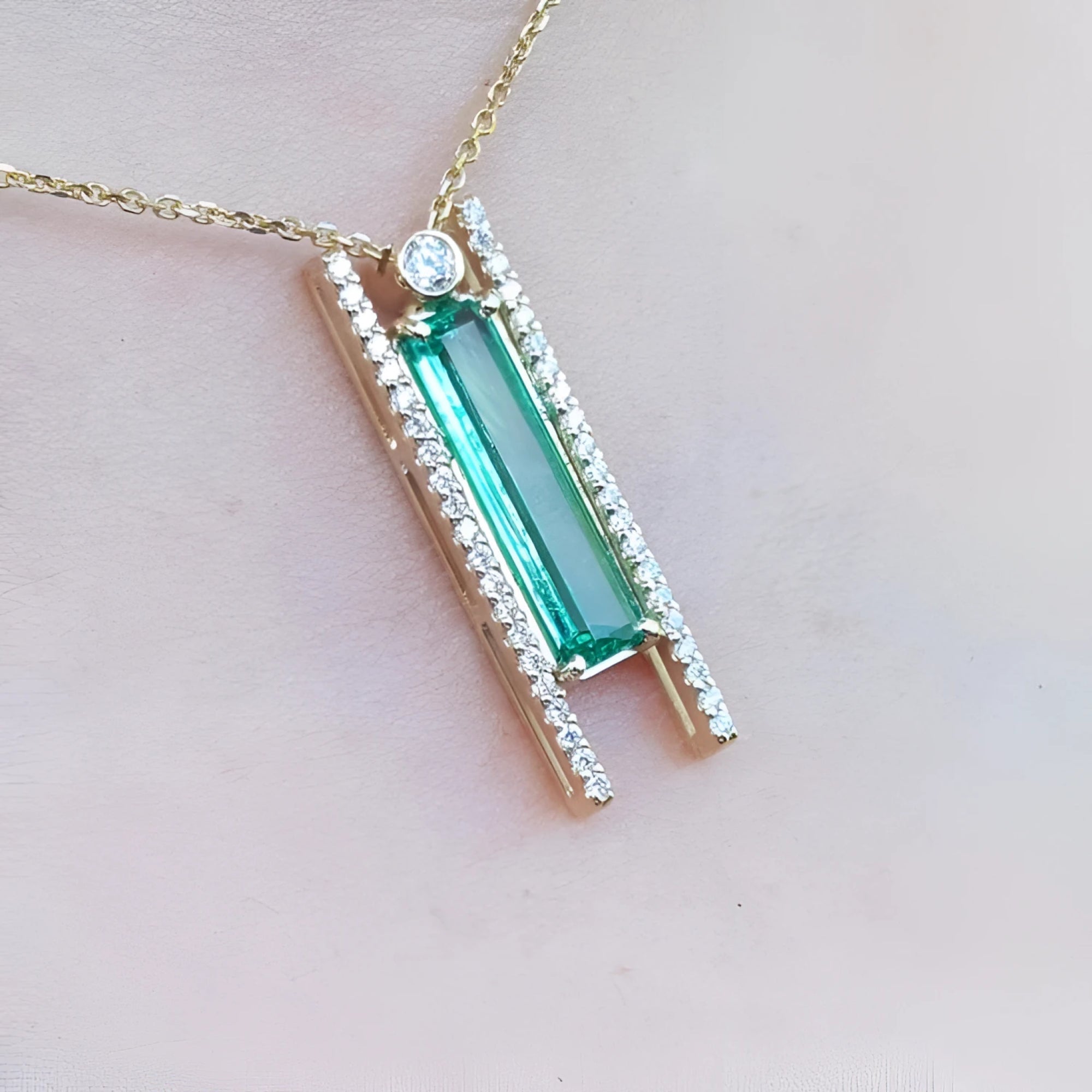 Emerald baguette cut necklace with natural diamonds, 14K yellow gold, and sliding tube bail chain.