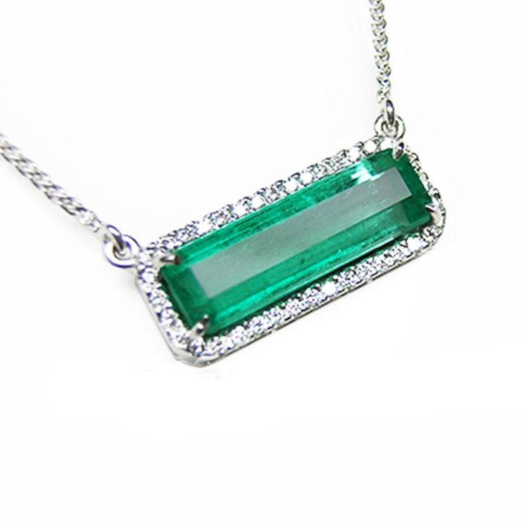 Elongated colombian emerald gemstone necklace encircled in a halo natural diamonds with white gold chain.