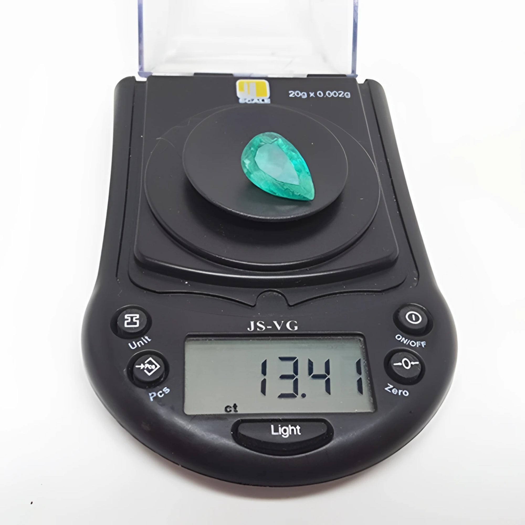 13.42 ct pear-cut Colombian emerald, medium green, on a digital scale displaying its carat weight.