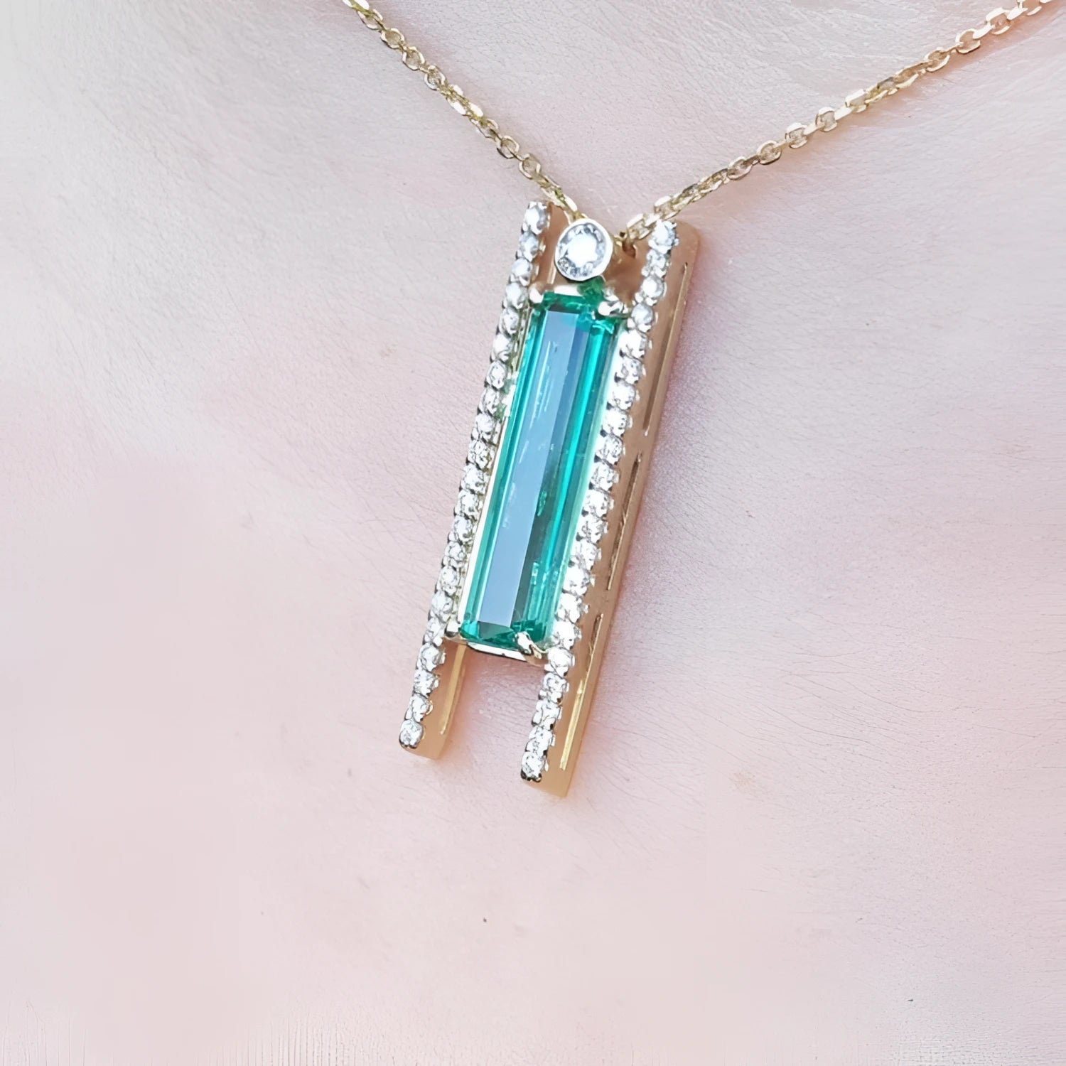 14K yellow gold necklace with a baguette-cut emerald and natural diamond accents.