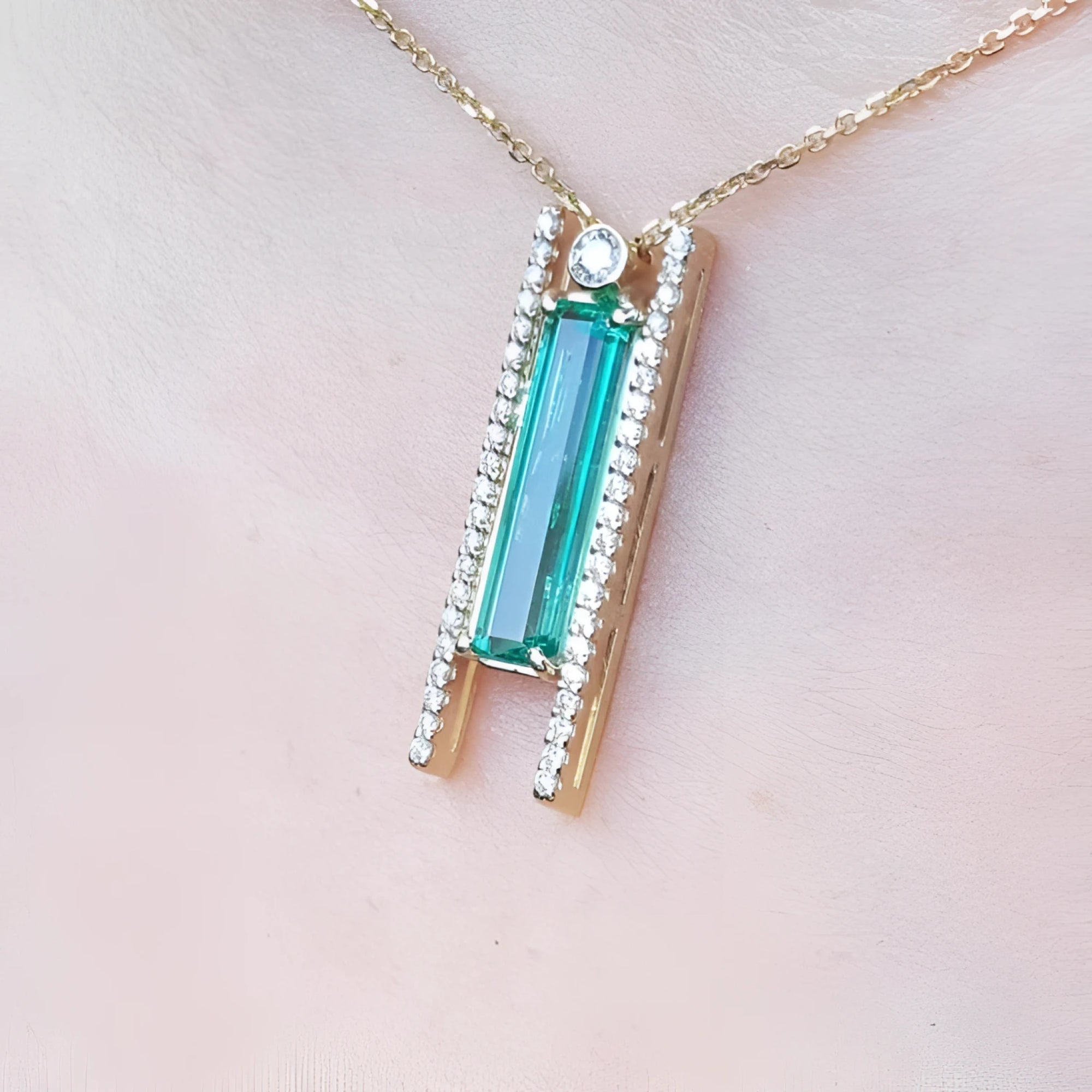 14K yellow gold necklace with a baguette-cut emerald and natural diamond accents.