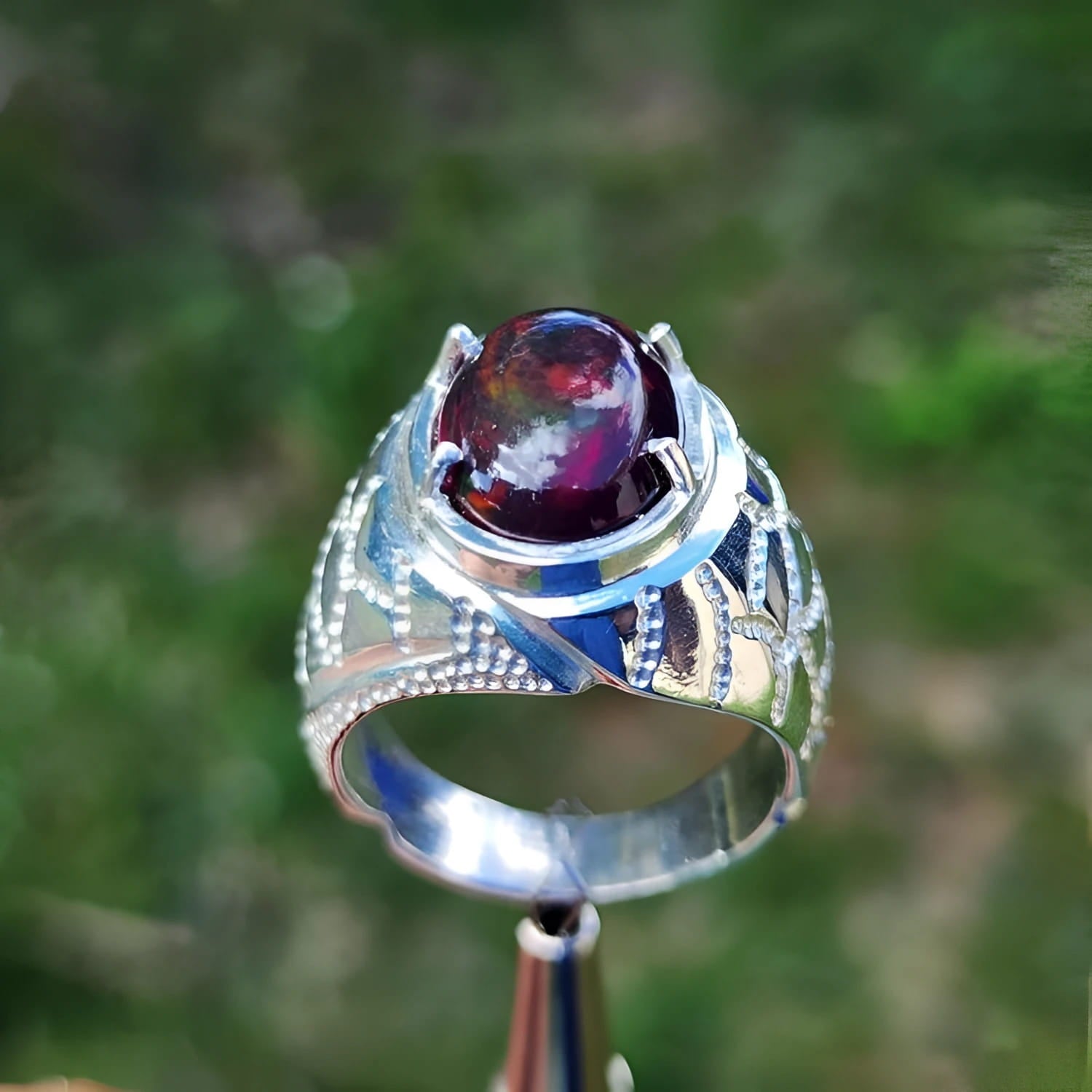 Men's sterling silver ring with a striking black Ethiopian opal gemstone, showing red-orange and blue hues.
