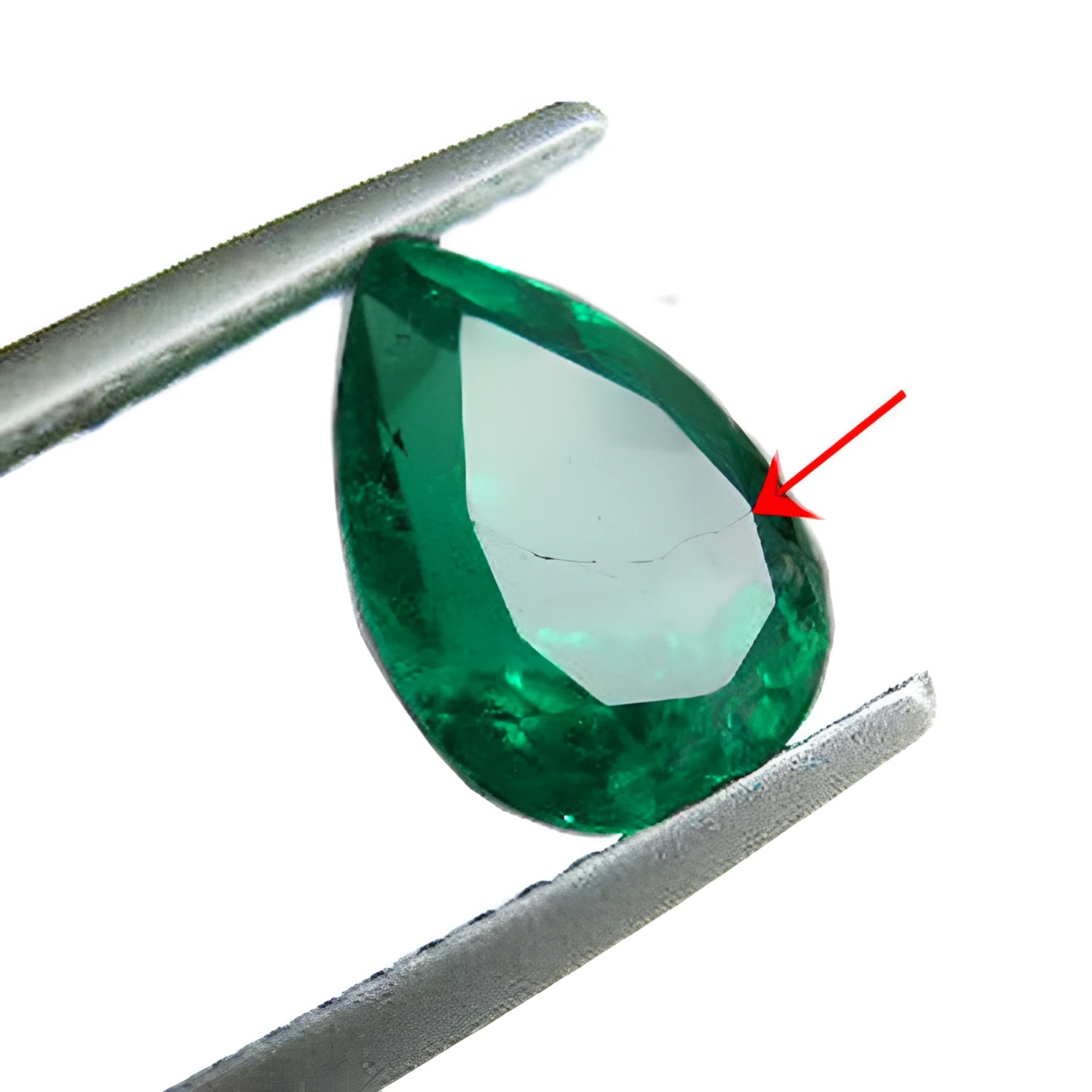 Teardrop-shaped emerald held by tweezers with a red arrow pointing to a synthetic filled fracture.