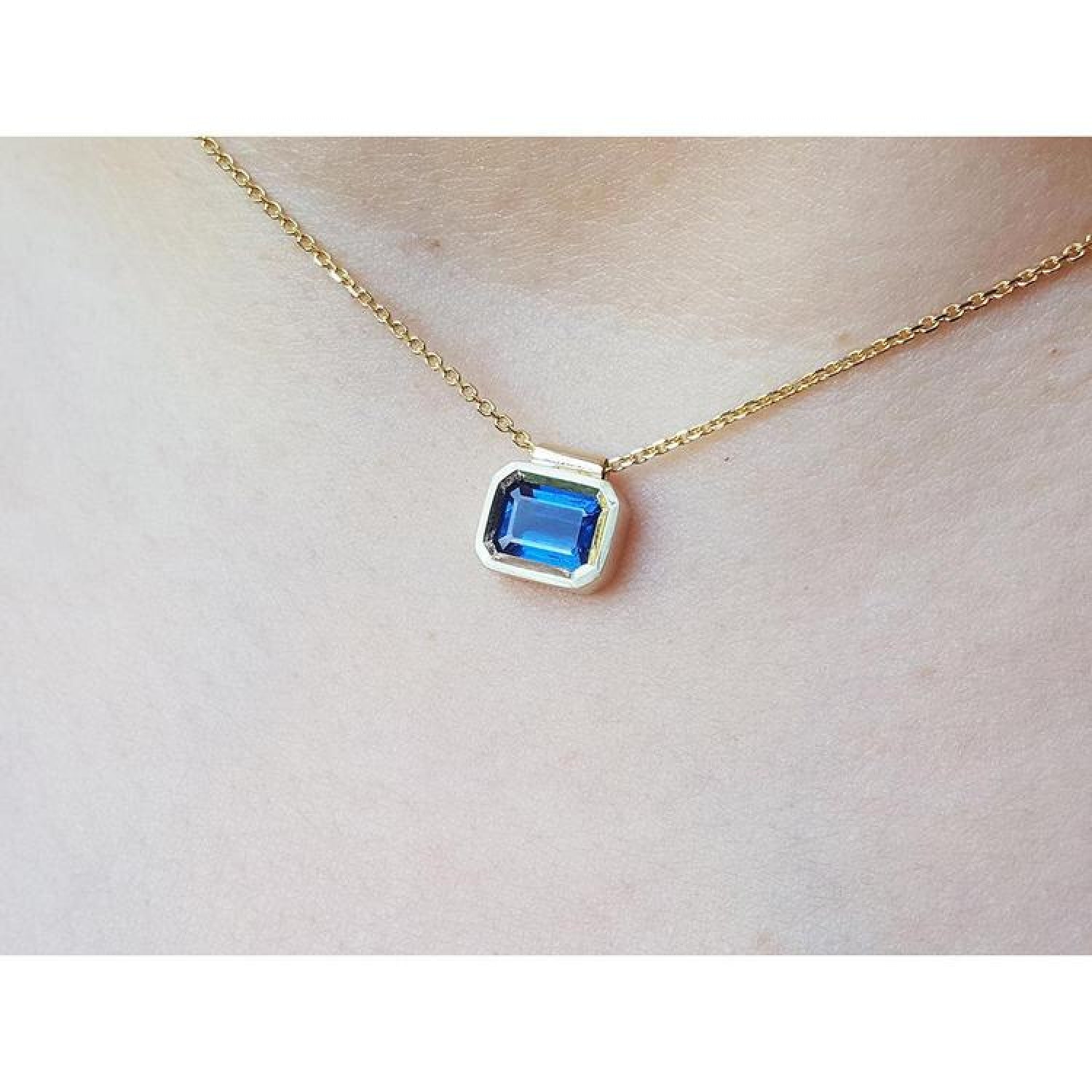 1.01 carat medium-dark blue sapphire choker necklace, bezel set in 14K gold on a cable chain.