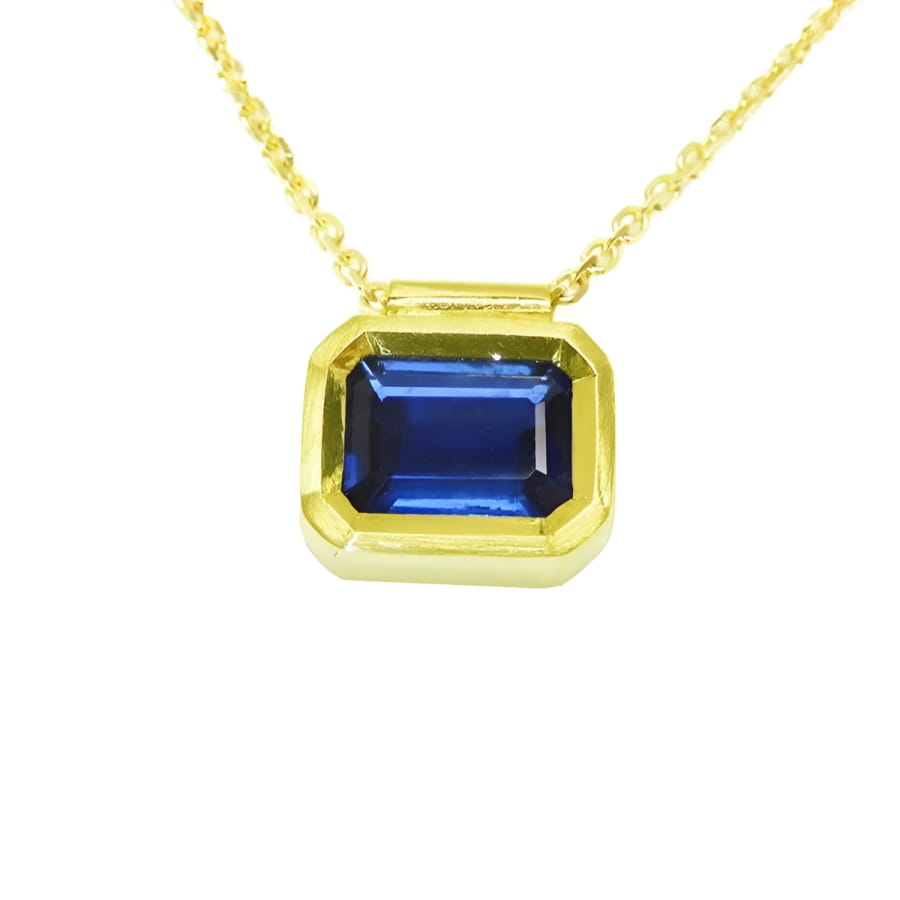 1.01 ct medium-dark blue sapphire choker, bezel set in 14K gold on a cable chain.