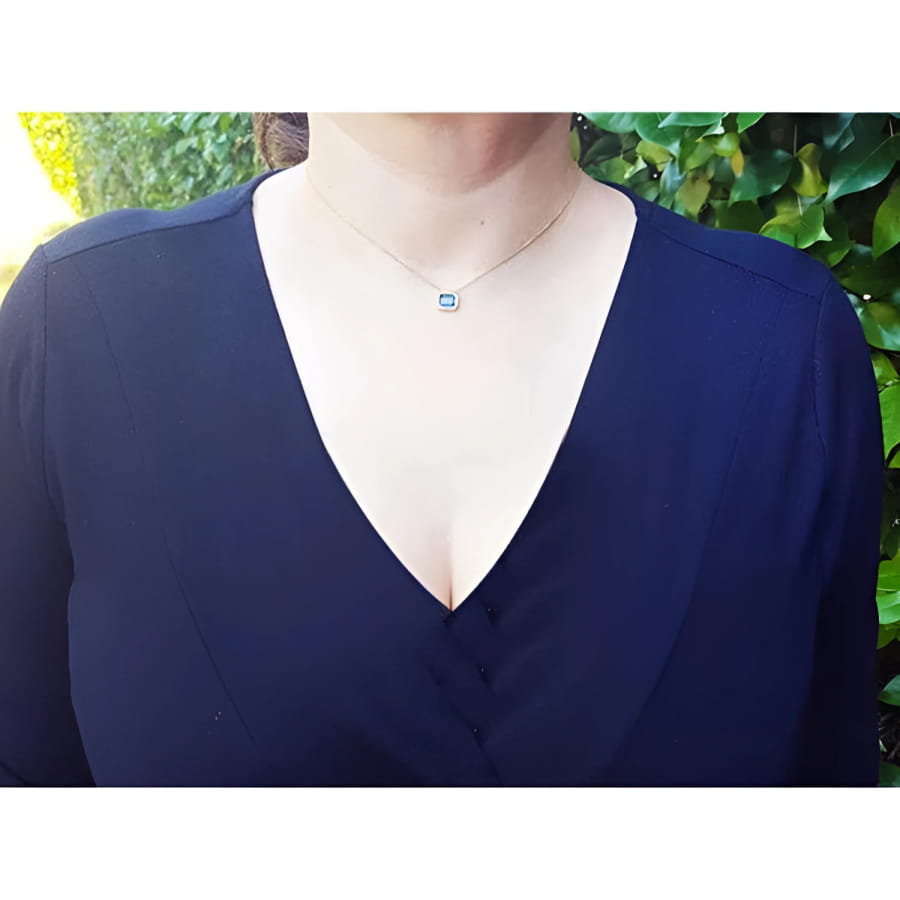 Woman wearing a 1.01 ct blue sapphire bezel-set choker on a 14K gold cable chain.