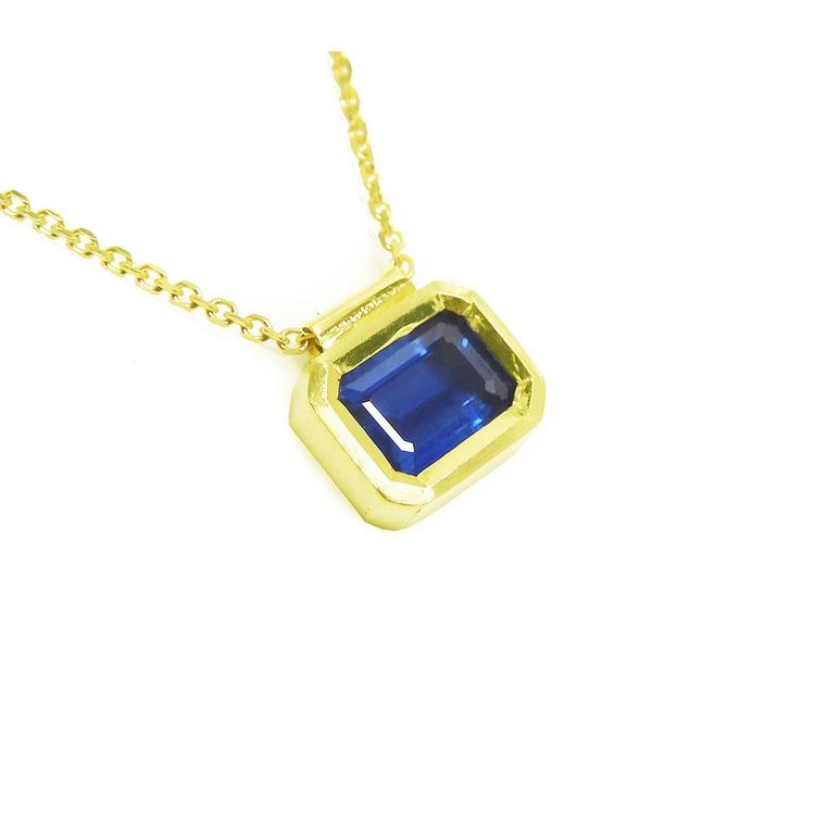 Viewing the right side of a blue sapphire choker necklace solitaire slider bezel set crafted in 14k yellow gold