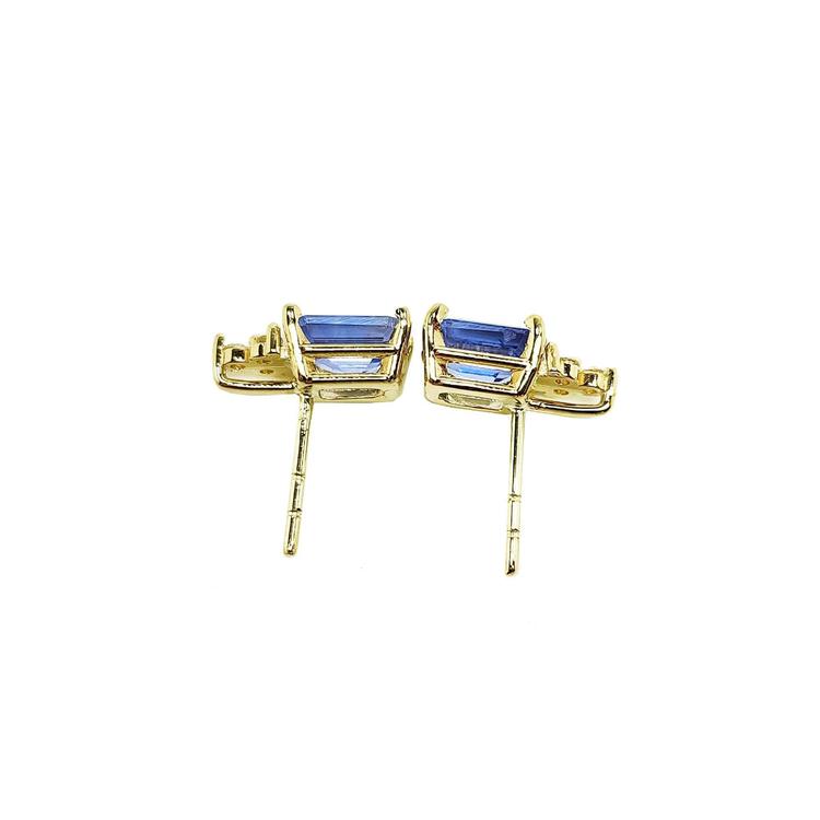 Gold earrings with blue gemstones on a downside view position