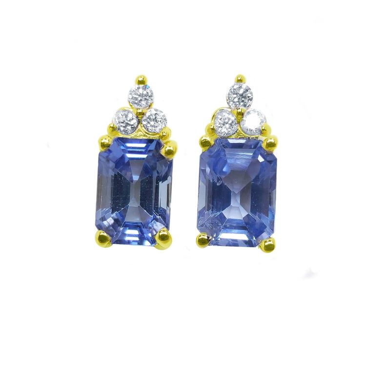 Pair of earrings with blue gemstones and gold accents on a white background