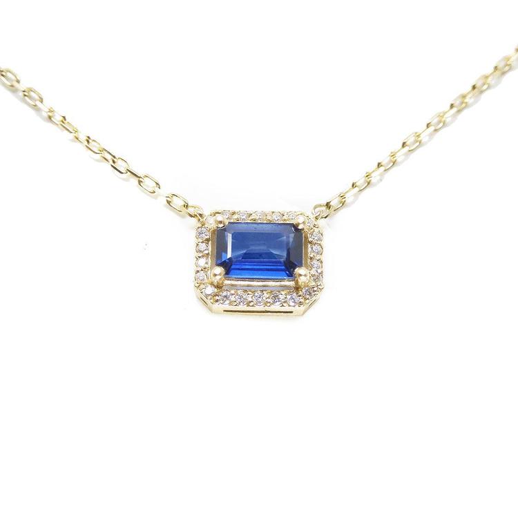 14K yellow gold necklace with an east-west emerald cut blue sapphire surrounded by diamonds.