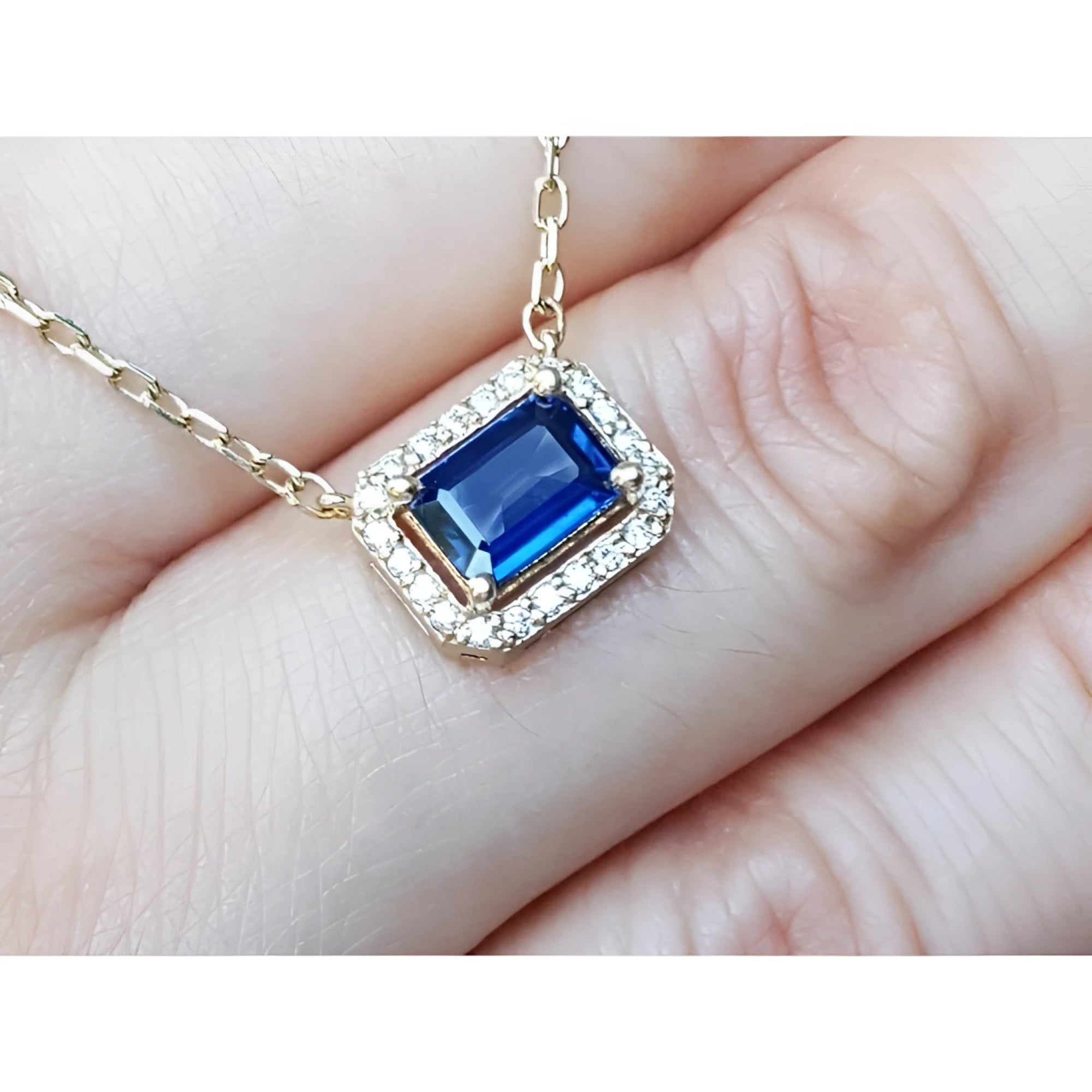 Blue sapphire necklace emerald cut in alo of natural diamonds set in 14k yellow gold.