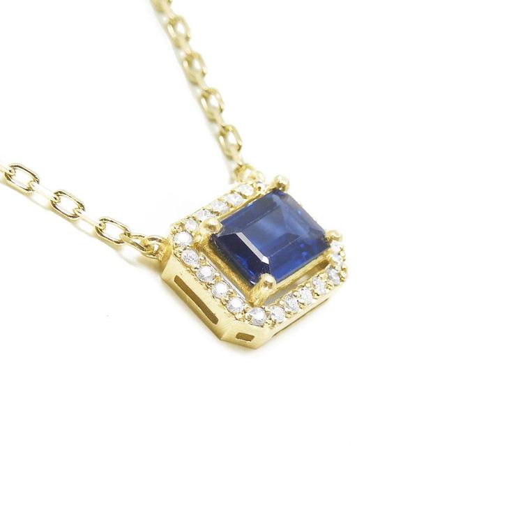 Right side profile, gallery exposed of a natural blue sapphire necklace emerald cut halo diamonds in 14k yellow gold.