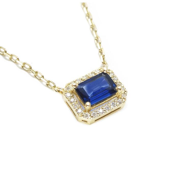 Right side top view of a natural blue sapphire necklace emerald cut halo diamonds in 14k yellow gold.