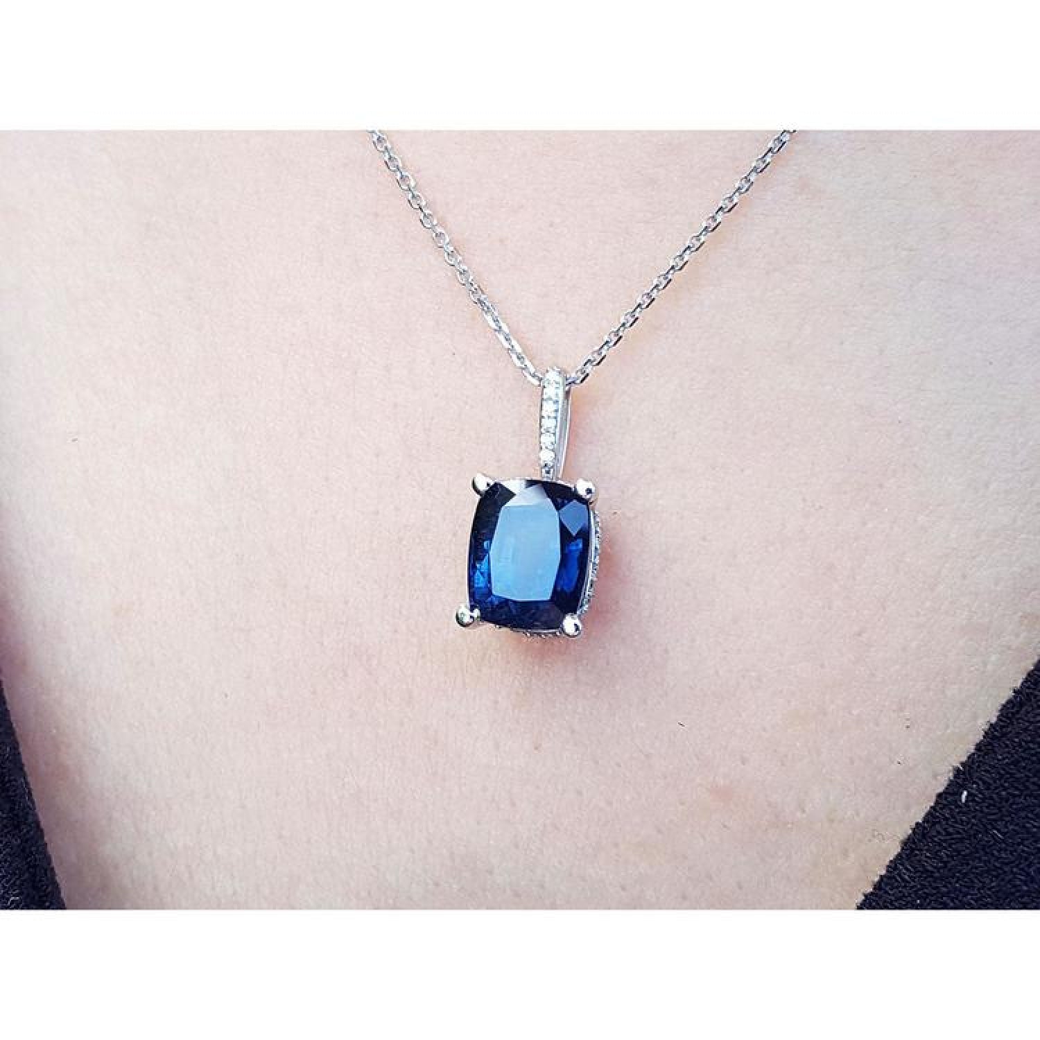 4.11 ct deep blue cushion cut sapphire pendant in 14K white gold on a necklace.