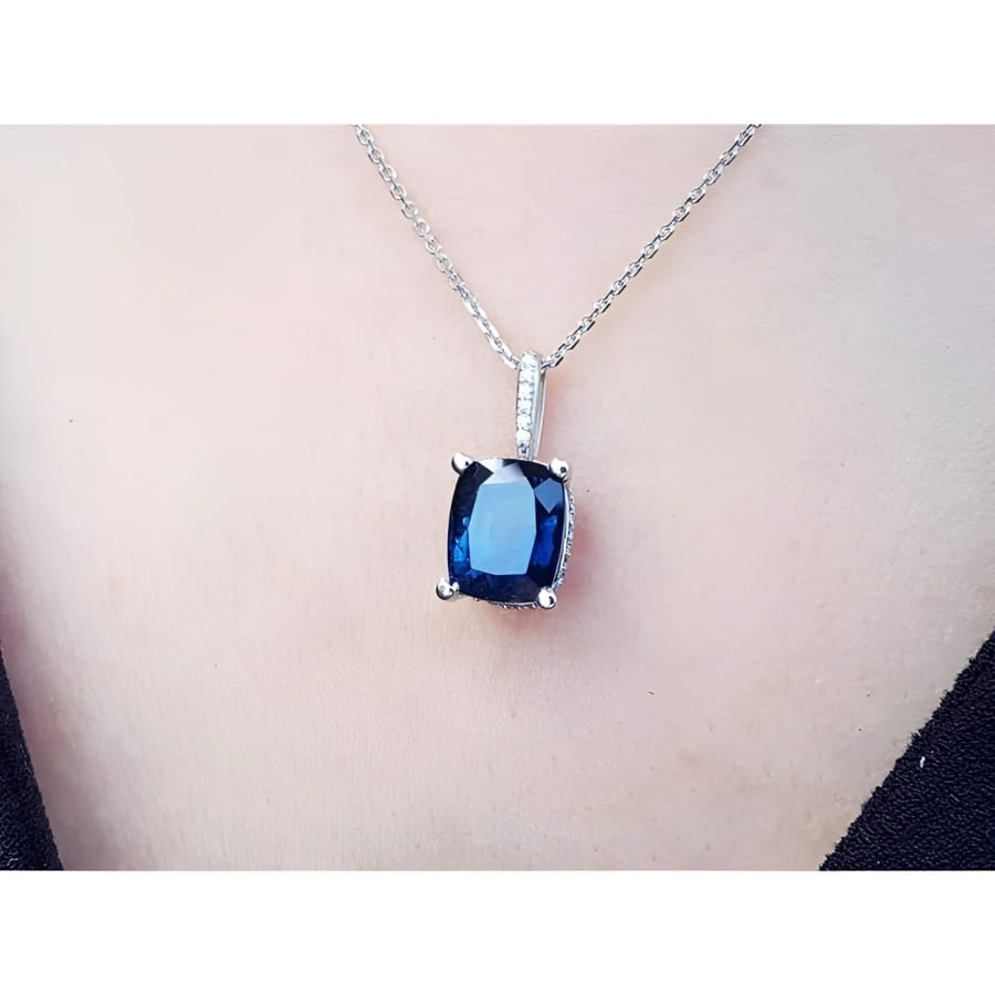 4.11 ct deep blue cushion cut sapphire pendant in 14K white gold on a necklace.