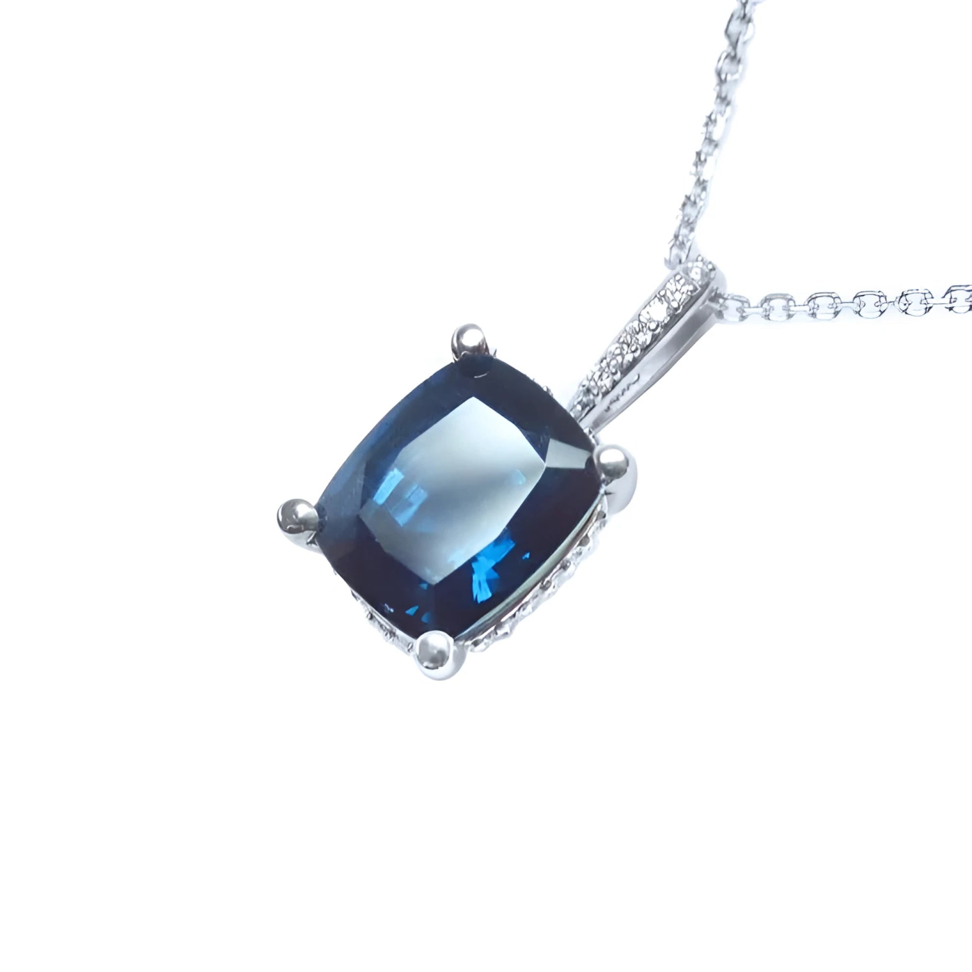 4.11 ct cushion cut deep blue sapphire solitaire pendant in 14K white gold with diamond accents.