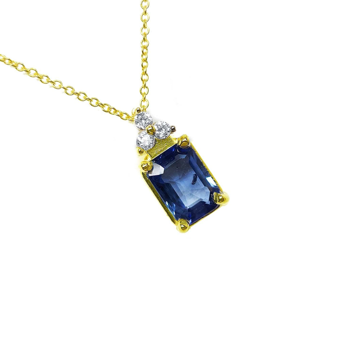 Gold necklace with a blue natural blue sapphire pendant on a right-side profile view.