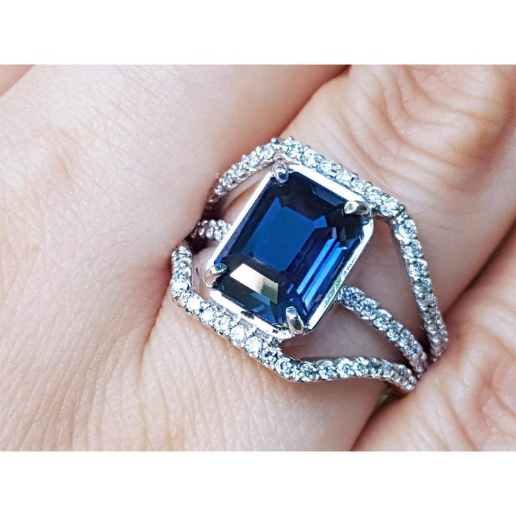 18k white gold ring with a natural blue sapphire certified gemstone held on a finger