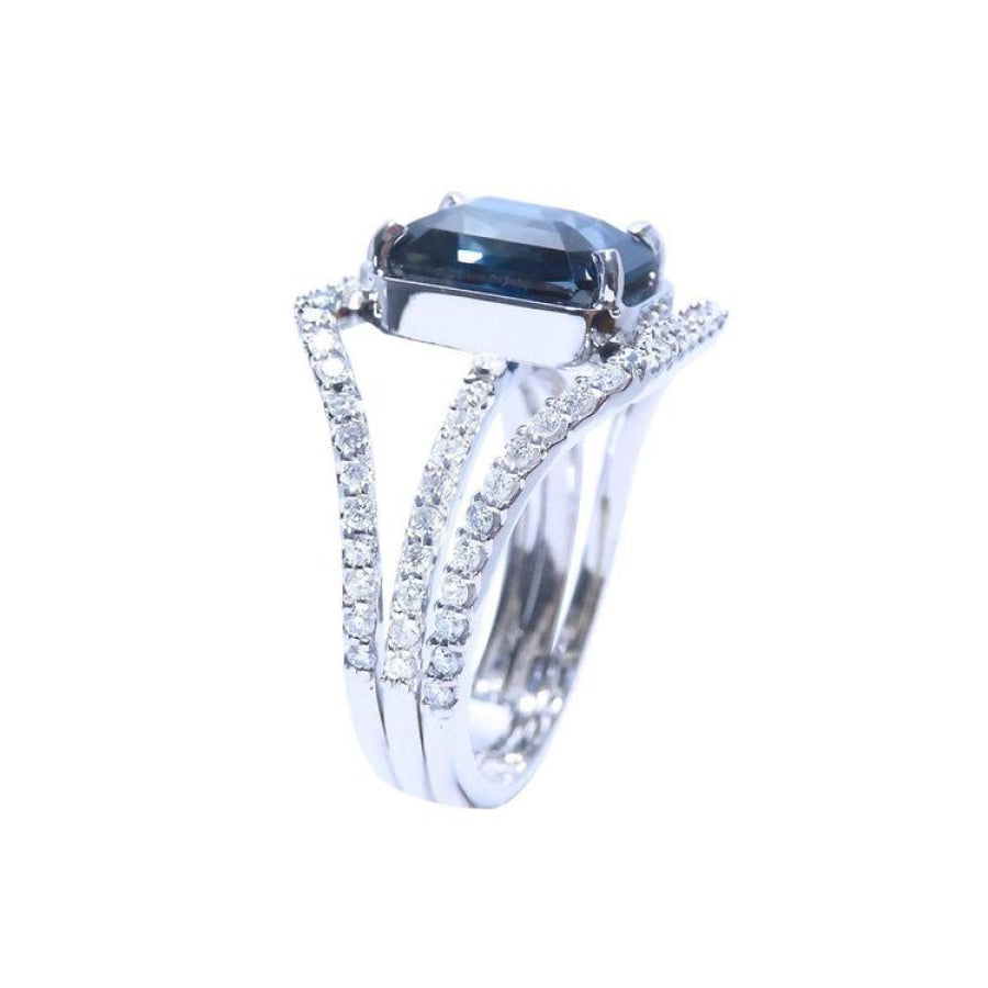 18K white gold ring with a 4.51 ct emerald cut blue sapphire and a three-row diamond band.