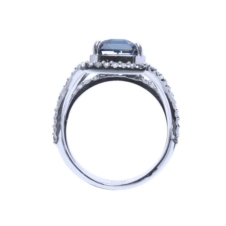 18K gold ring with a 4.51 ct emerald cut blue sapphire and a three-row diamond band.