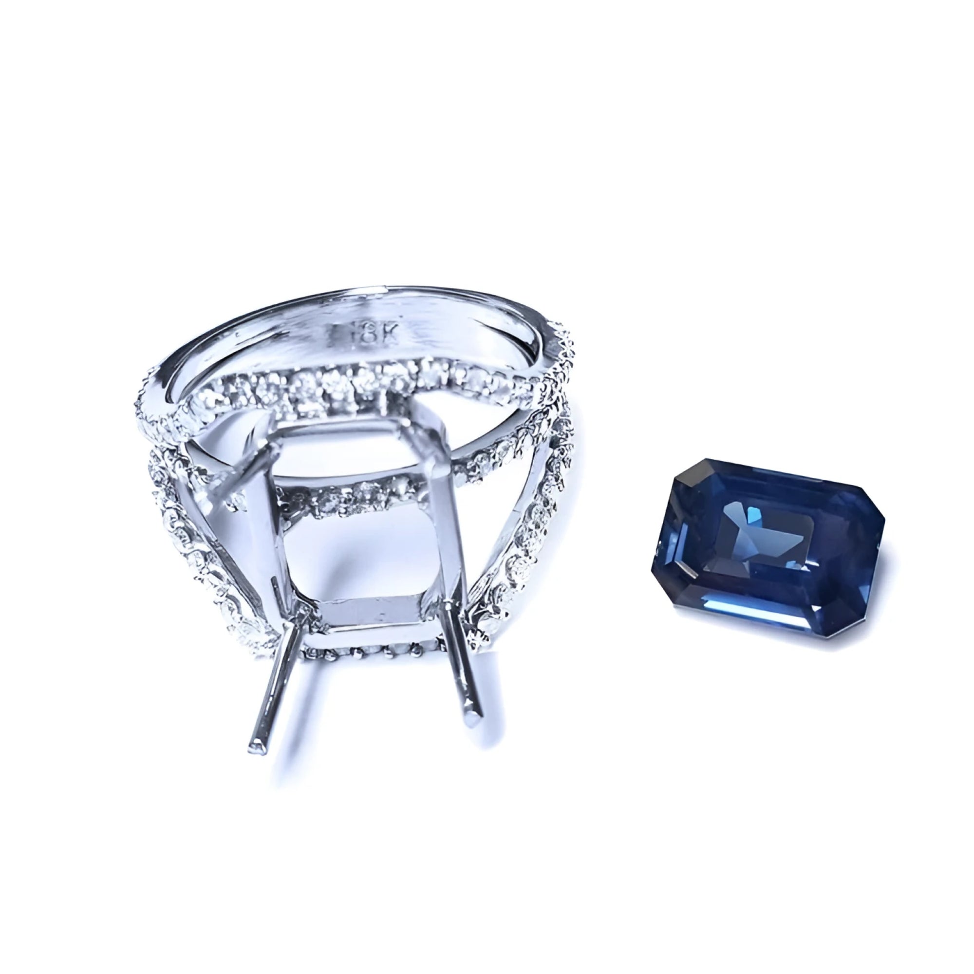 18K white gold diamond ring setting next to a loose 4.51 ct emerald cut blue sapphire.
