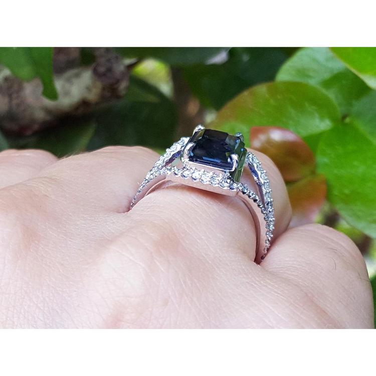 4.51 ct emerald cut blue sapphire ring with a three-row diamond band in 18K gold.