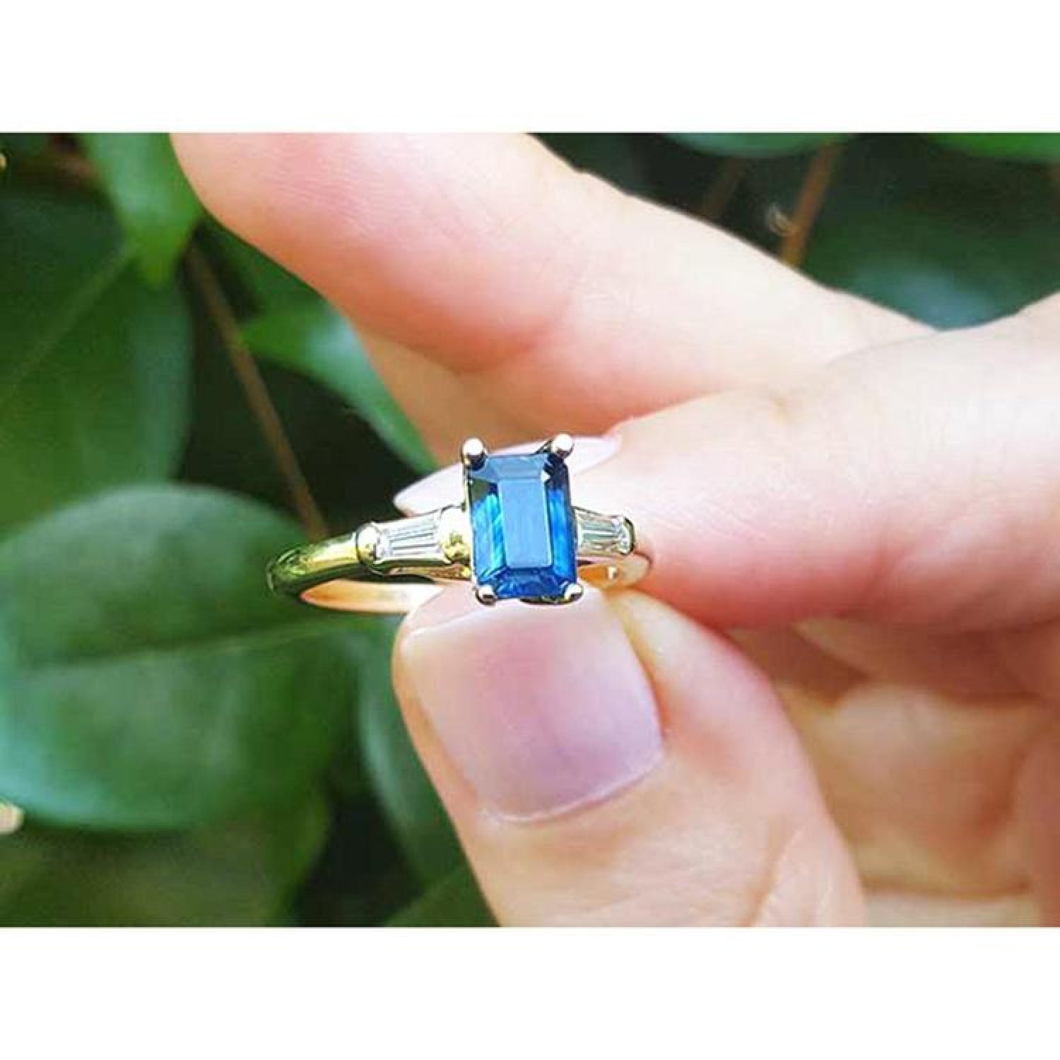 Women's 14K yellow gold ring with a 1.13 ct. emerald-cut blue sapphire and tapered baguette diamonds.