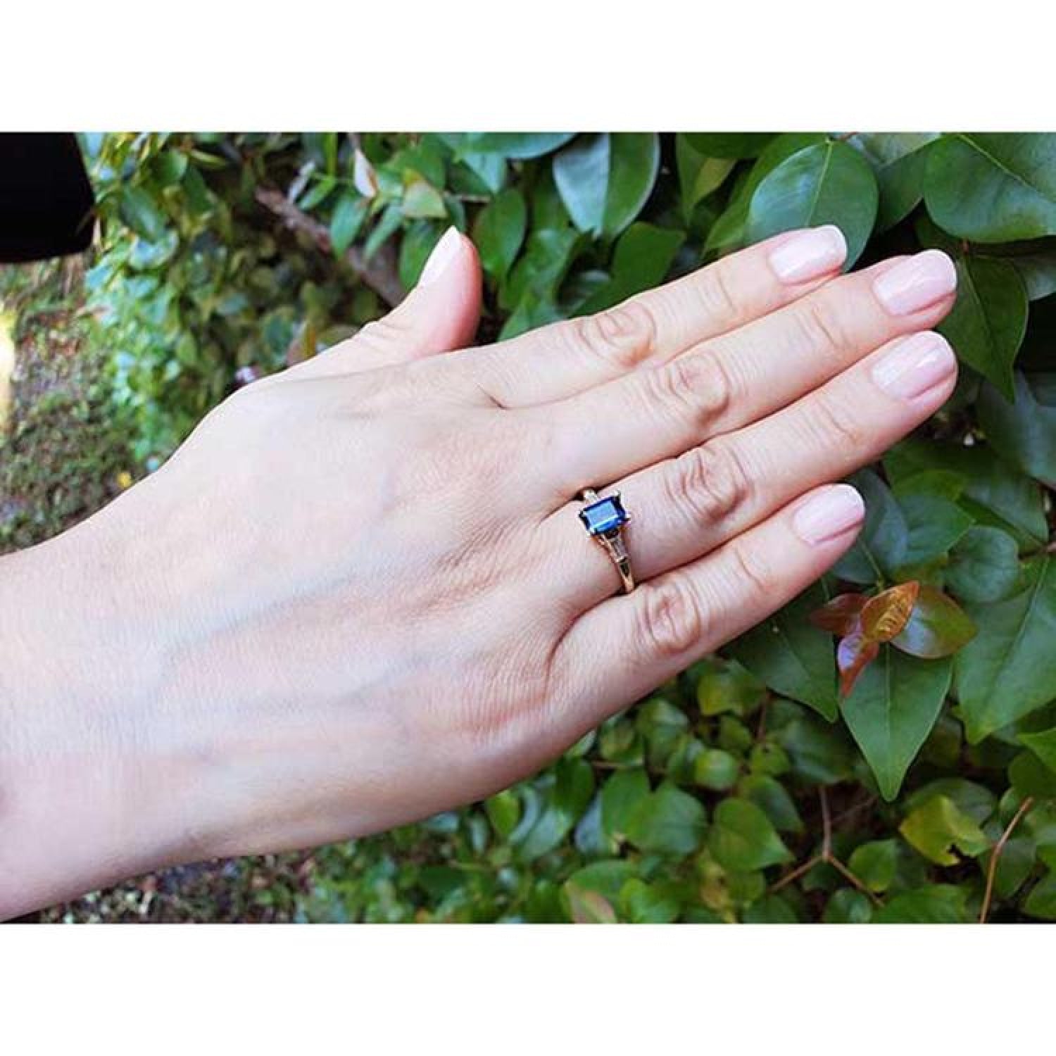 Women's 14K yellow gold ring with a rectangular blue sapphire and tapered diamond accents.