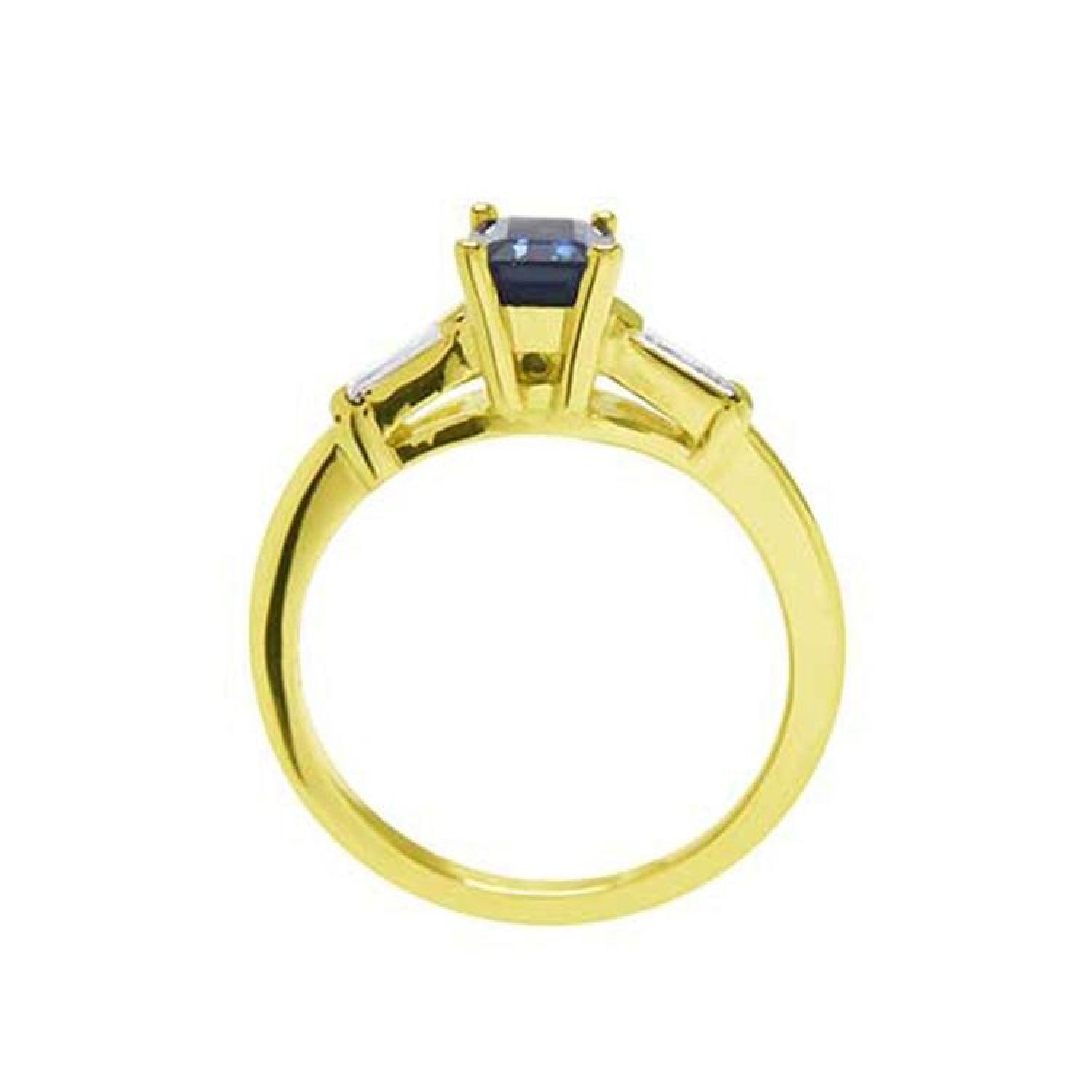 1.13 ct. emerald-cut blue sapphire ring with tapered diamonds in 14K yellow gold.