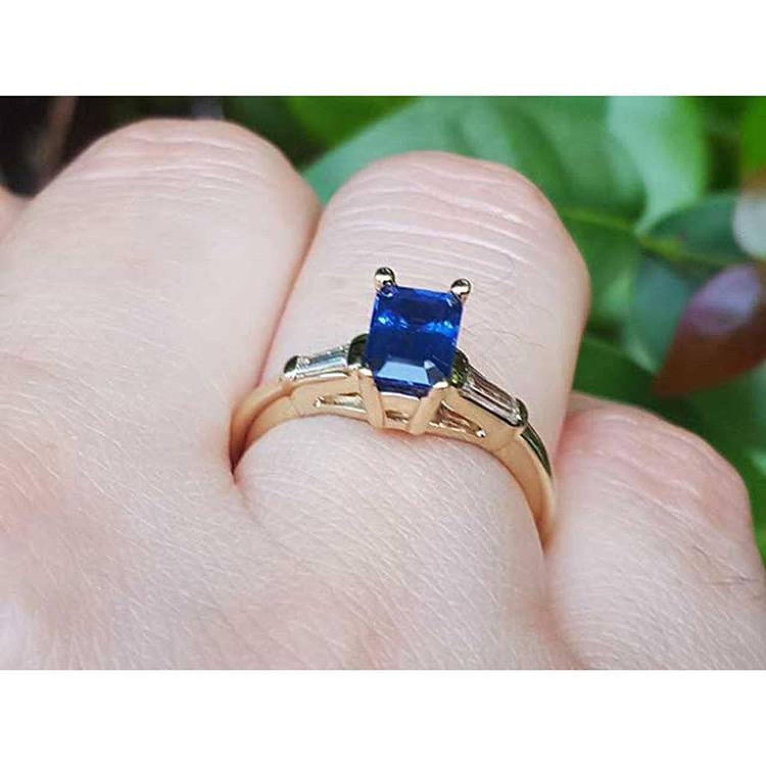 Women's 14K yellow gold ring with a rectangular blue sapphire and tapered baguette diamonds.