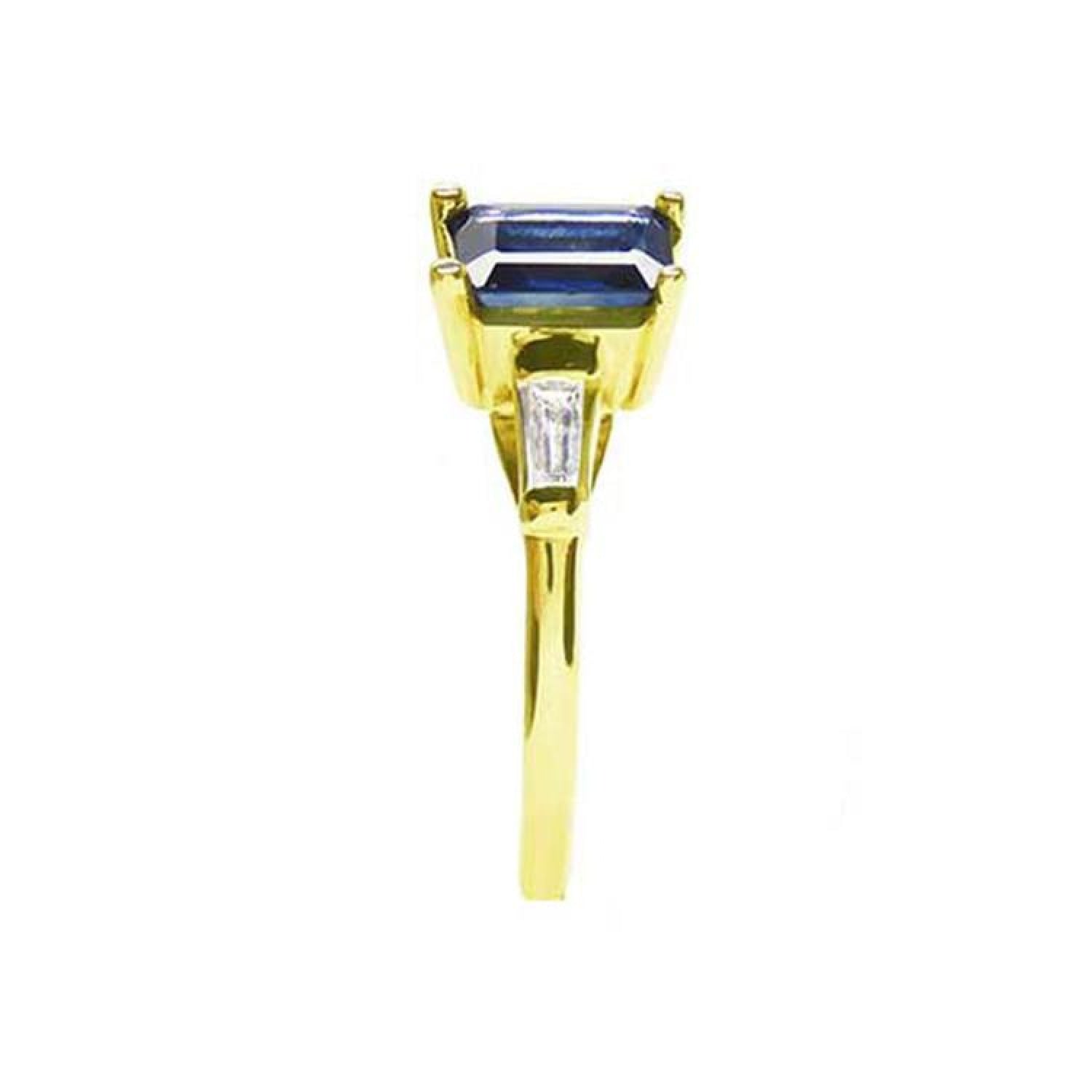 14K yellow gold ring with a rectangular emerald-cut blue sapphire and tapered baguette diamonds.