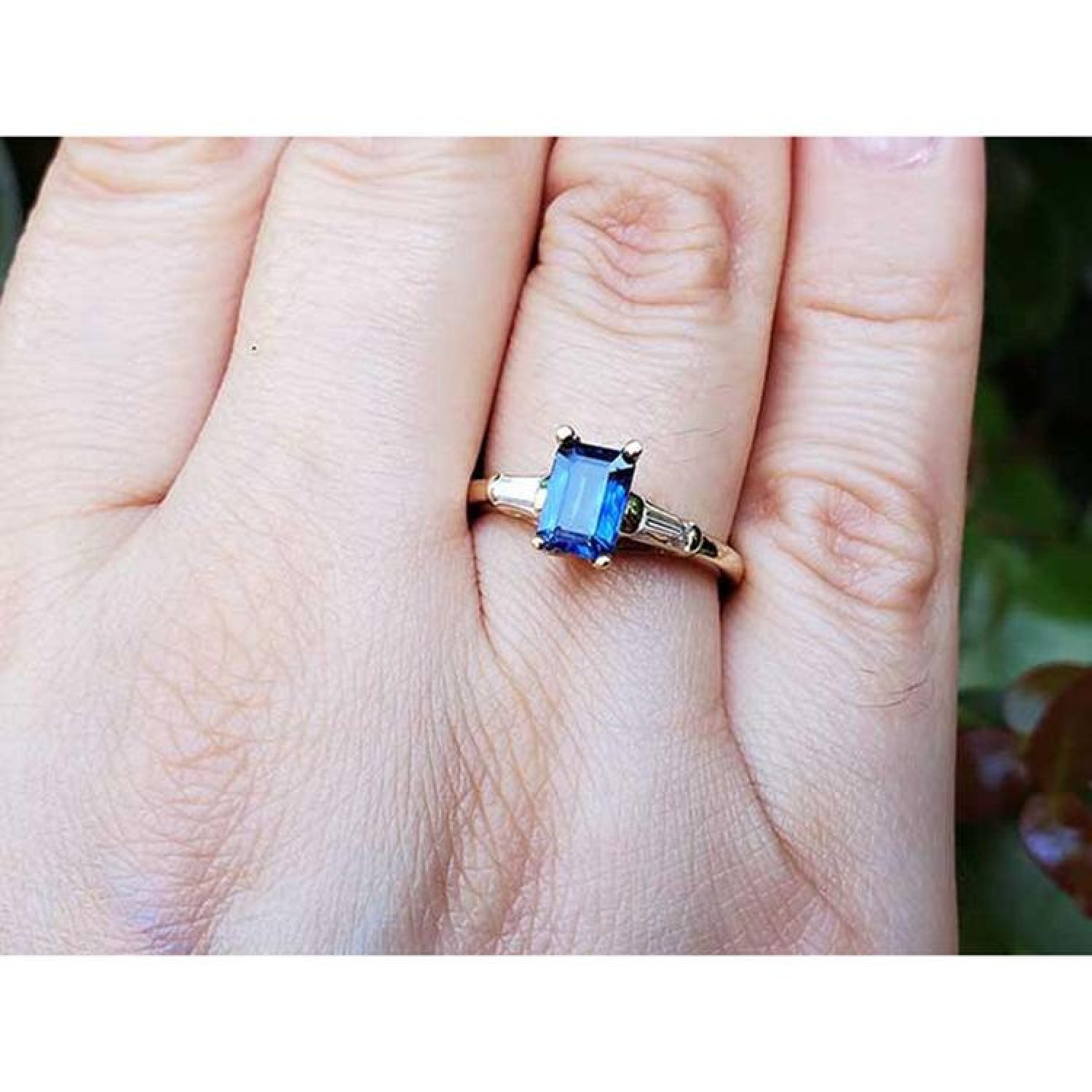 Women's 14K yellow gold ring with a rectangular blue sapphire and tapered baguette diamonds.