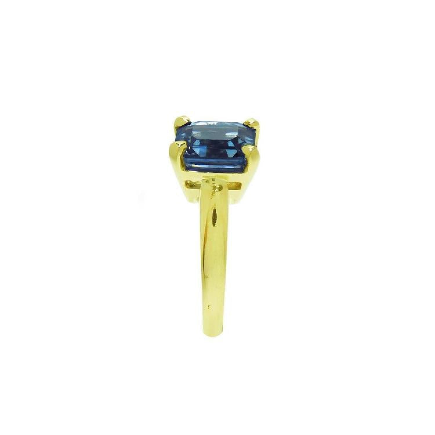3.13 ct. emerald cut deep blue sapphire solitaire ring in 14K yellow gold.