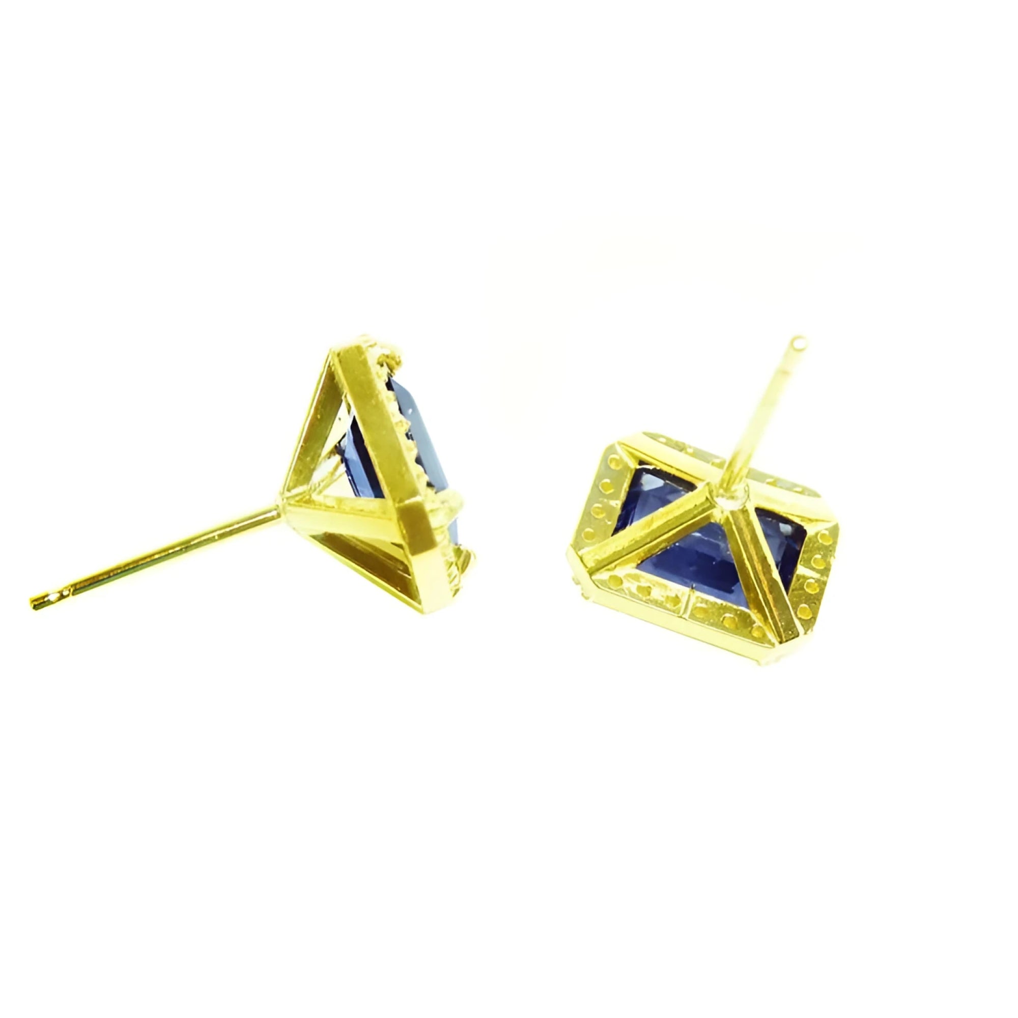 Emerald cut blue sapphire stud earrings with halo diamonds in 14K yellow gold.