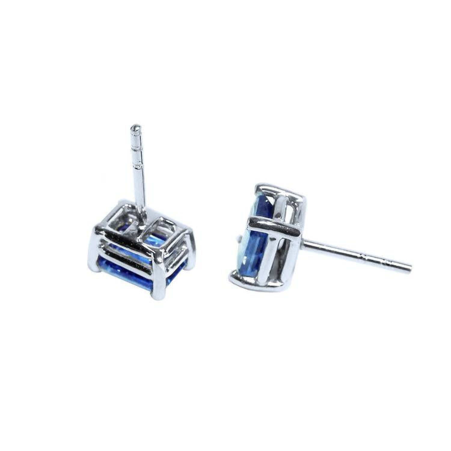 Pair of emerald-cut natural sapphire stud earrings in 14K white gold with four-prong basket settings.