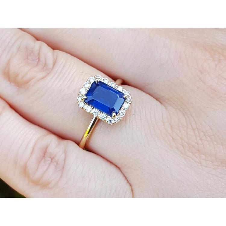 14k yellow gold ring with a blue natural sapphire halo diamond on a hand