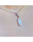 Necklace with a teardrop-shaped pendant on a person's neck