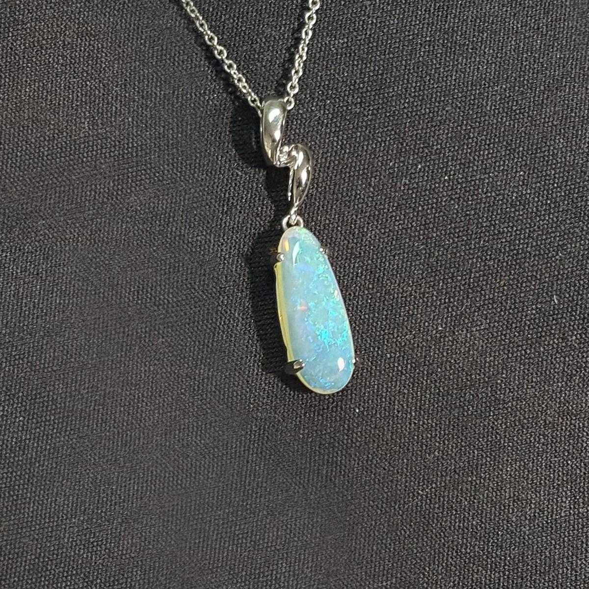 Opal pendant necklace on a dark fabric background