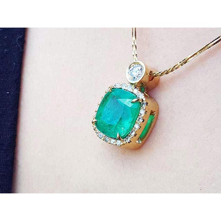 Cushion-cut Colombian emerald necklace with halo diamonds in 18K yellow gold.