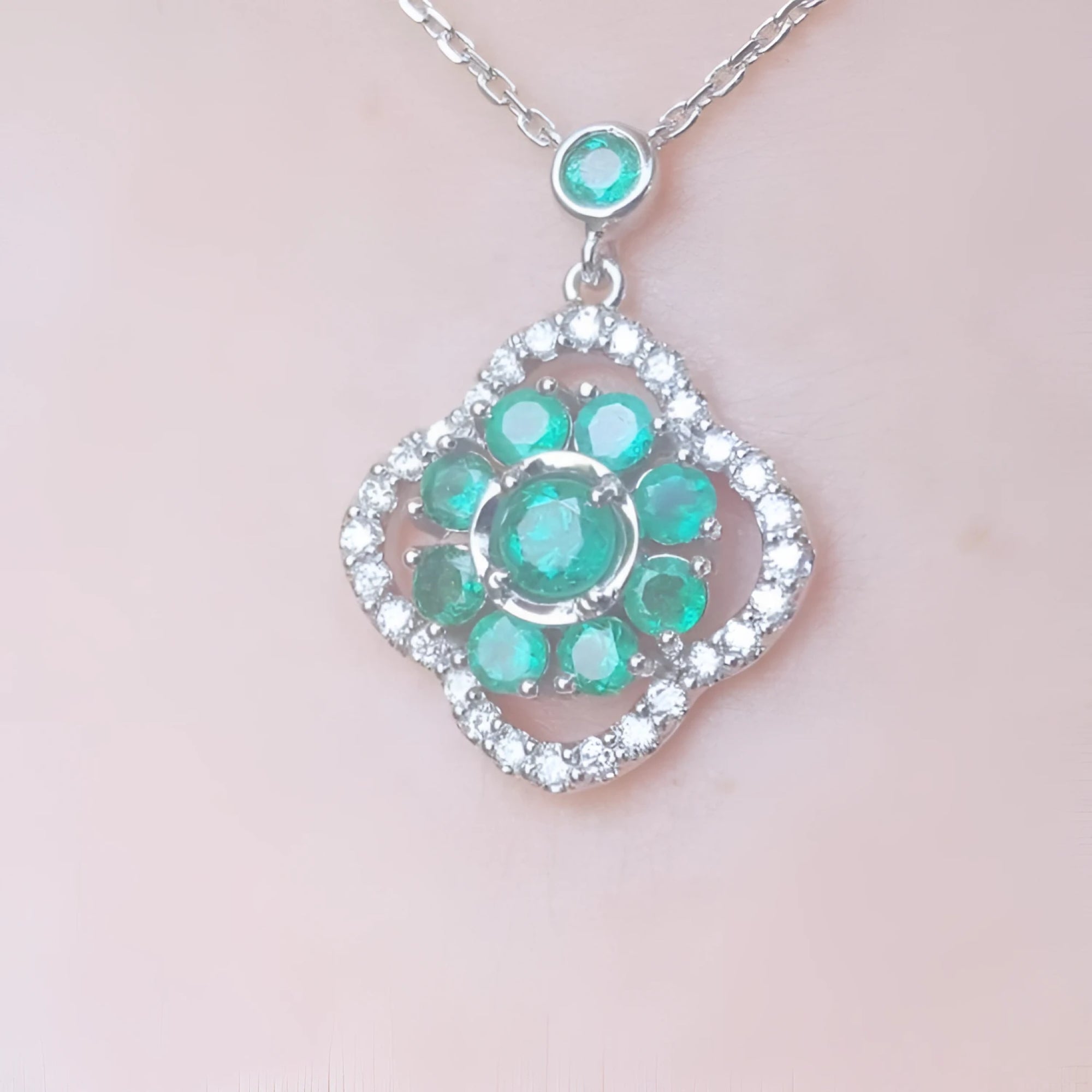 14K white gold cluster necklace with natural Colombian emeralds and diamond 4-leaf clover silhouette.