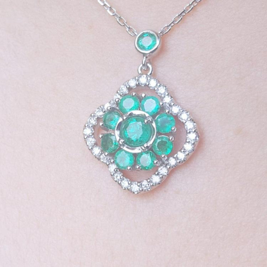 14K white gold cluster necklace with natural Colombian emeralds and diamond 4-leaf clover silhouette.