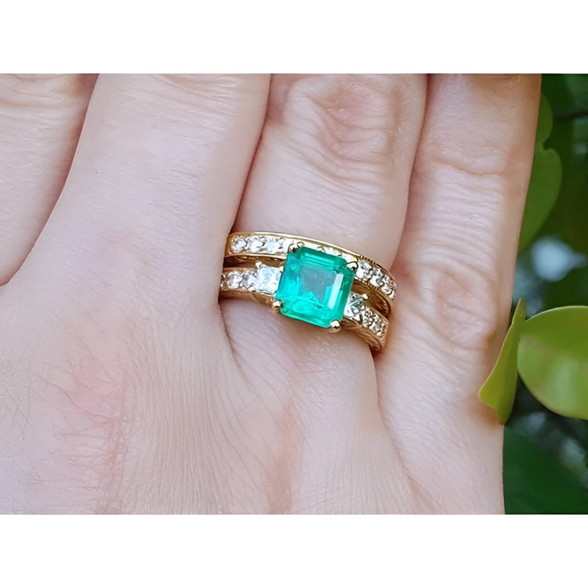 Natural emerald and diamond ring with match wedding band 14k yellow gold on a person's figer.