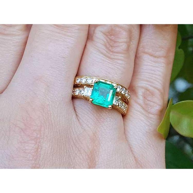 Natural emerald and diamond ring with match wedding band 14k yellow gold on a person's figer.