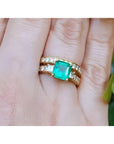 Natural emerald and diamond ring with match wedding band 14k yellow gold on a person's figer.