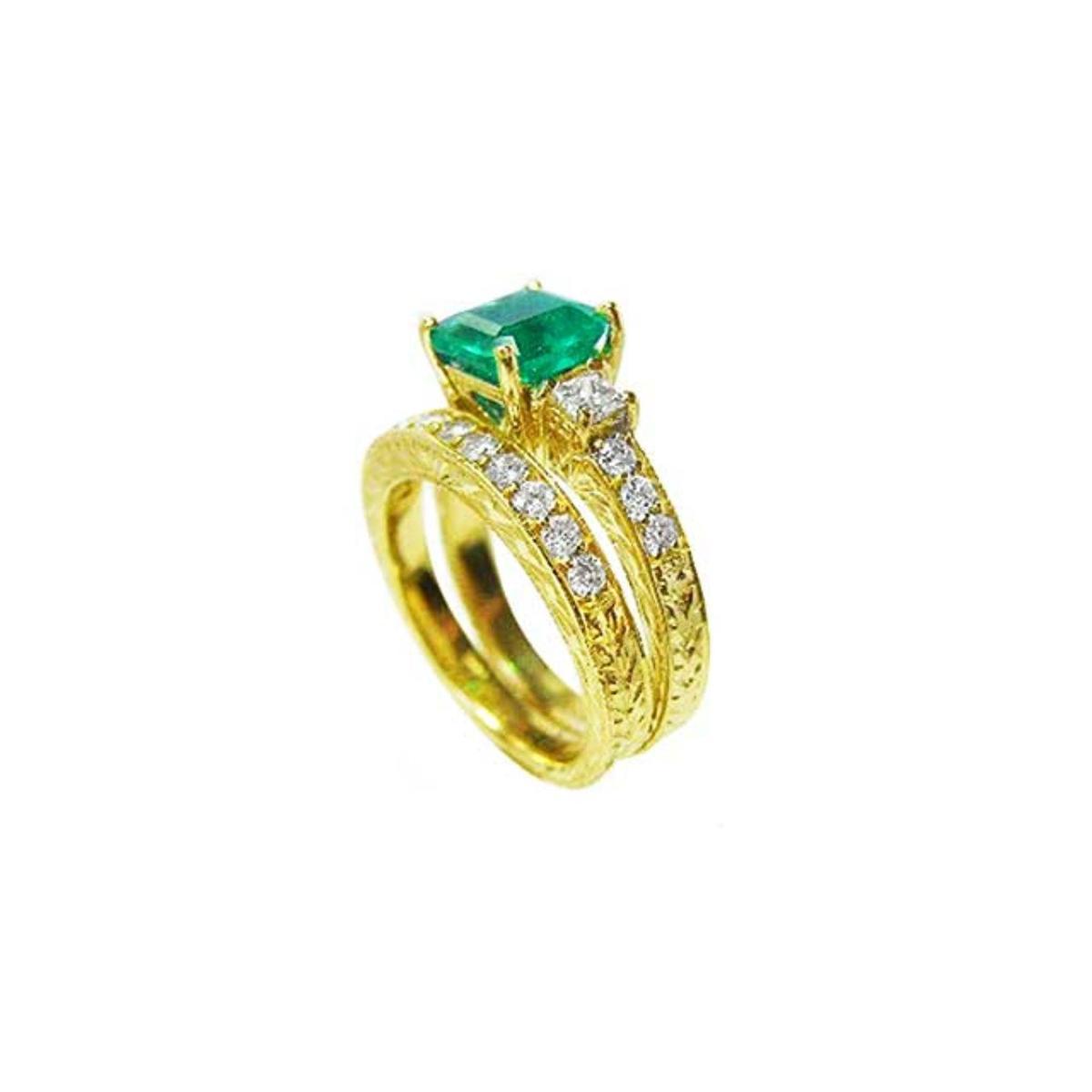 Displaying a bridal wedding band and the matching emerald ring together side profile. 